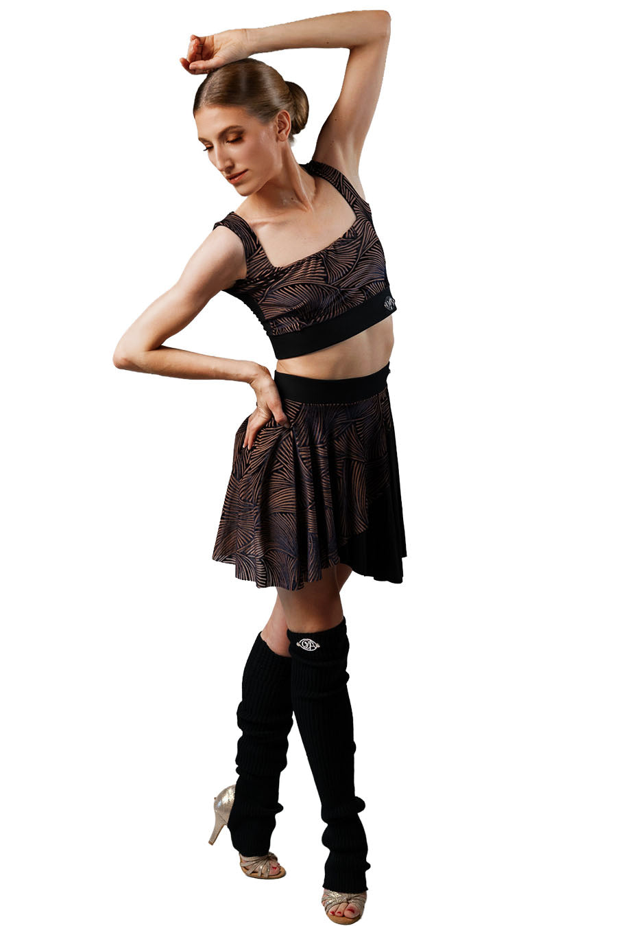 Dancer in a black outfit with a skirt and knee-high boots on a white background